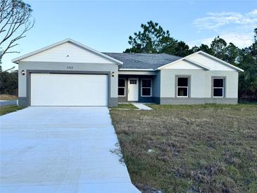 Newly constructed home with a two-car garage and a landscaped yard at 1212 Baltic Dr Way, Poinciana, FL 34759