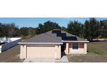 One-story house with solar panels, attached garage, and fenced backyard at 1238 Conch Key Ln, Davenport, FL 33837