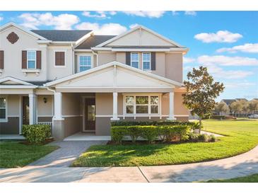 Two-story townhome with neutral siding, front porch, and manicured lawn at 13715 Bressler Aly, Windermere, FL 34786