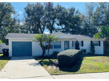 Newly renovated home with a bright white exterior and teal garage door at 1414 Rolling Green Dr, Apopka, FL 32703