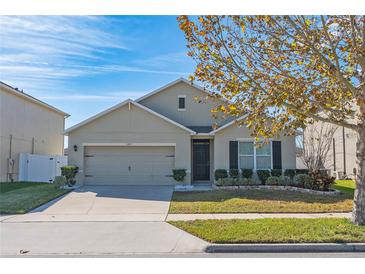 Charming single-story home with a well-manicured lawn and a two-car garage on a sunny day at 1470 Silverado Flats St, Kissimmee, FL 34744