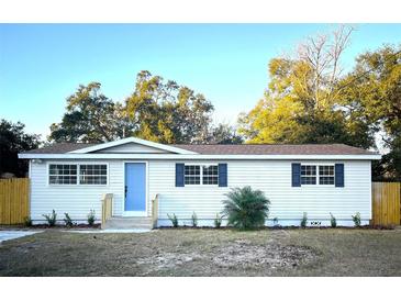 Newly renovated single story home with a blue door and landscaped yard at 2120 Waitman Ave, Leesburg, FL 34748