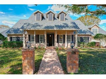 Charming brick home with black shutters, dormer windows, and inviting brick pathway leading to the front door at 2511 Madron Ct, Orlando, FL 32806