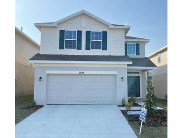 Two-story house with white siding, gray garage door, and landscaping at 3019 Tackle Drive, Leesburg, FL 34748