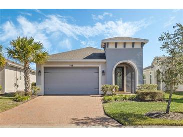 One-story home with gray exterior, brick driveway and landscaping at 308 Vestrella Dr, Kissimmee, FL 34759