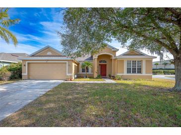 Tan house exterior with red door and attached garage at 405 Kehoe Blvd, Orlando, FL 32825