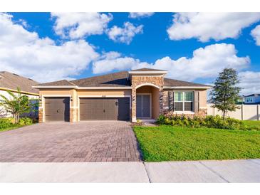 New 3-car garage home with paver driveway and landscaped lawn at 4767 Cragmere Loop, Clermont, FL 34711