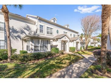 Two-story townhome with gray exterior, landscaping, and walkway at 5159 Wellington Park Cir # 36, Orlando, FL 32839