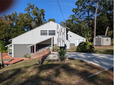 Unique gray two-story home with creative vertical column design and inviting driveway and landscaping at 800 Lake Marion Dr, Altamonte Springs, FL 32701