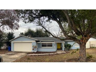 Light blue single story home with attached garage and landscaped yard at 1218 Russell Dr, Ocoee, FL 34761