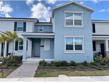 Two-story light blue house with a landscaped front yard and walkway at 1904 Tohoqua Blvd, Kissimmee, FL 34744