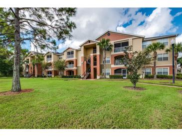 Attractive condo building with manicured lawn and landscaping at 1910 Summer Club Dr # 110, Oviedo, FL 32765