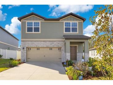 Two-story house with stone accents and a two-car garage at 1991 Hemingway Cir, Groveland, FL 34736