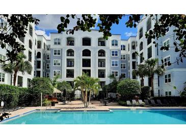 Resort-style pool at a condo complex, surrounded by lounge chairs, palm trees, and a tiki bar at 202 E South St # 1050, Orlando, FL 32801