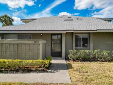 Exterior view of condo with landscaped grounds and walkway at 4409 Prairie Ct # A, Orlando, FL 32808