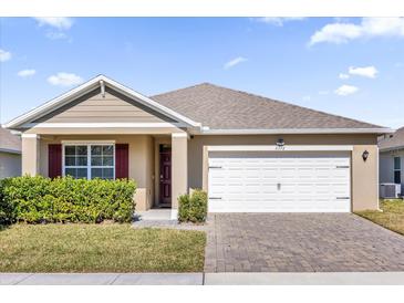 One-story house with tan siding, red shutters, and a white garage door at 5372 Palomino Pl, Apopka, FL 32712