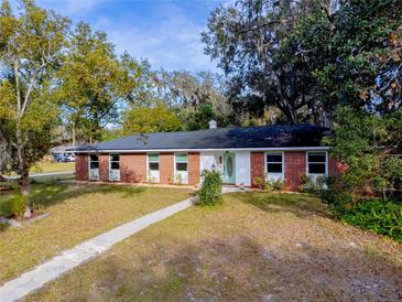 Brick ranch house with a landscaped yard and walkway at 646 Palm Dr, Oviedo, FL 32765