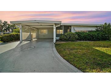 Single-story home with carport and landscaped yard at 711 Dolphin Dr, Tavares, FL 32778