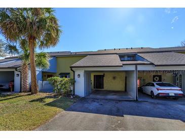 Front view of a two-story townhouse with a carport and well-maintained landscaping at 7482 Canford Ct # 9, Winter Park, FL 32792