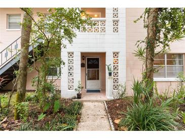 Exterior view of a charming light pink building with lush landscaping at 802 Rugby St # 802, Orlando, FL 32804