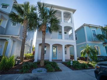 Three-story home with light blue accents and palm trees at 8044 Lost Shaker Ln, Kissimmee, FL 34747