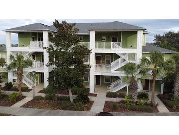 Green two-story building with white columns and multiple staircases at 910 Gran Bahama Blvd # 910, Davenport, FL 33897