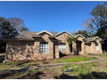 Brick home with landscaped yard and a large driveway at 1017 Pearl Tree Rd, Deltona, FL 32725