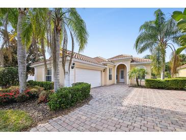 Single-story home with tile roof, two-car garage, and landscaped front yard at 12161 Obelia Ln, Orlando, FL 32827