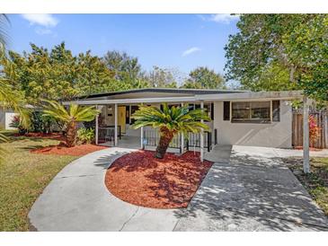 Charming mid-century home with a covered entryway and lush landscaping at 145 Verbena Dr, Orlando, FL 32807