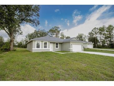 Newly constructed home with a green lawn and attached garage at 16391 Sw 17Th Terrace Rd, Ocala, FL 34473