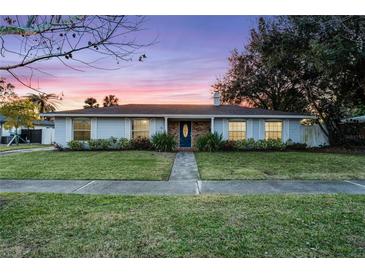 Nice curb appeal! Updated light gray home with a blue door and landscaped lawn at 1818 Foxboro Dr, Orlando, FL 32812