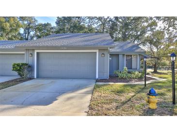 Gray exterior of a single story home with a two-car garage and well-maintained landscaping at 1890 Silver Fern Dr, Port Orange, FL 32128