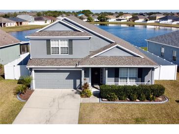 Two-story house with gray siding, a two-car garage, and a landscaped front yard at 3105 Dasha Palm Dr, Kissimmee, FL 34744