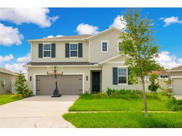 Two-story house with gray siding, dark shutters, and a basketball hoop in the front yard at 332 Bow Ln, Haines City, FL 33844