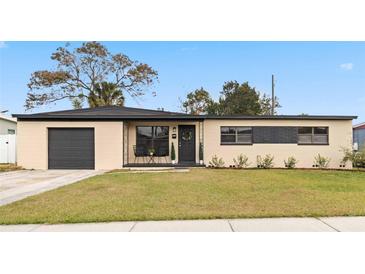 Updated ranch home with a modern facade, two-car garage, and well-manicured lawn at 4301 Lancashire Ln, Orlando, FL 32812