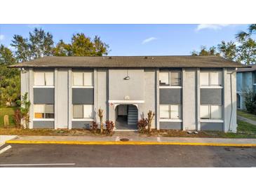 Front view of a two-story building with gray siding, multiple windows, and a paved parking area at 4767 S Texas Ave # 4767C, Orlando, FL 32839