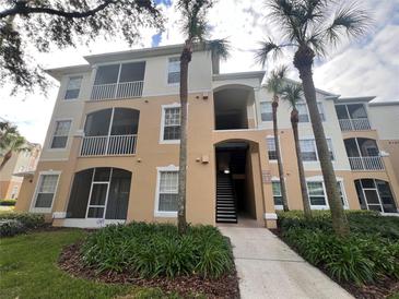 Exterior view of a condo building with palm trees and landscaping at 6100 Stevenson Dr # 105, Orlando, FL 32835