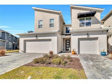 Two-story townhome with attached garages and landscaping at 914 Spring Palms Loop, Orlando, FL 32828