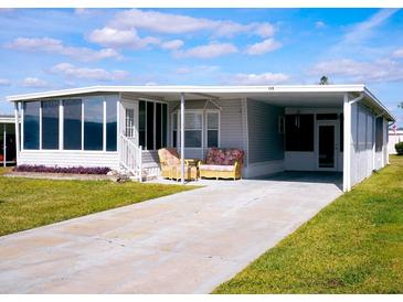 Mobile home with carport, covered patio, and landscaped lawn at 1401 W Highway 50 # 138, Clermont, FL 34711