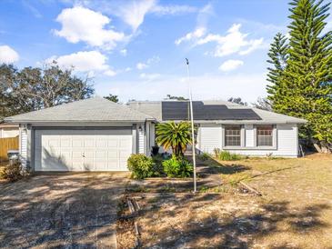 House exterior with solar panels and a grassy yard at 1950 Baton Rouge Ct, Orlando, FL 32818