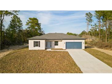 Charming single-story home featuring a blue garage door, neutral paint, and a well-manicured front yard at 709 Marion Oaks Mnr, Ocala, FL 34473