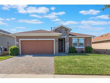 Single-story home with a two-car garage and landscaped lawn at 125 Silver Maple Rd Rd, Groveland, FL 34736