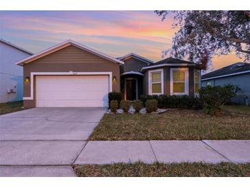 One-story house with a two-car garage and landscaped front yard at 1569 Tamarind Rd, Davenport, FL 33896