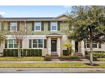 Two-story townhome with green exterior, landscaping, and a two-car garage at 16133 Pebble Bluff Loop, Winter Garden, FL 34787