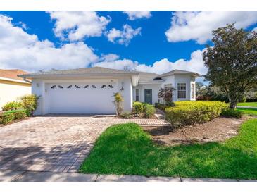 Single-story home with a white exterior, a two-car garage, and a landscaped yard at 181 Tall Pines Pass, Kissimmee, FL 34759