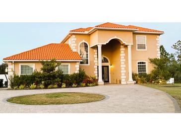 Two-story house with orange tile roof, columns, and landscaped yard at 19229 E Peabody St, Orlando, FL 32833