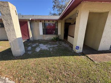 Tan house exterior with a red door and a small front yard at 4032 Doral, Winter Haven, FL 33884