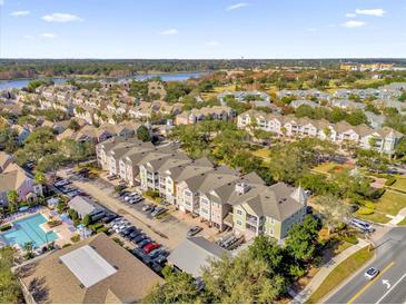 Spacious neighborhood featuring townhomes, lush landscaping, a community pool, and nearby lake at 6413 Astor Village Ave # 313, Orlando, FL 32835