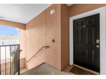 Inviting entryway with a modern black door and neutral-colored walls at 6413 Astor Village Ave # 313, Orlando, FL 32835