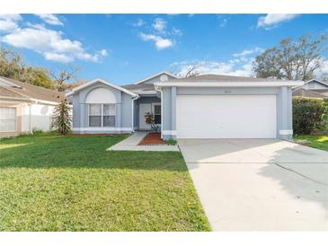 Charming single-story home with a well-manicured lawn and a two-car garage at 7812 Wicklow Cir, Orlando, FL 32817